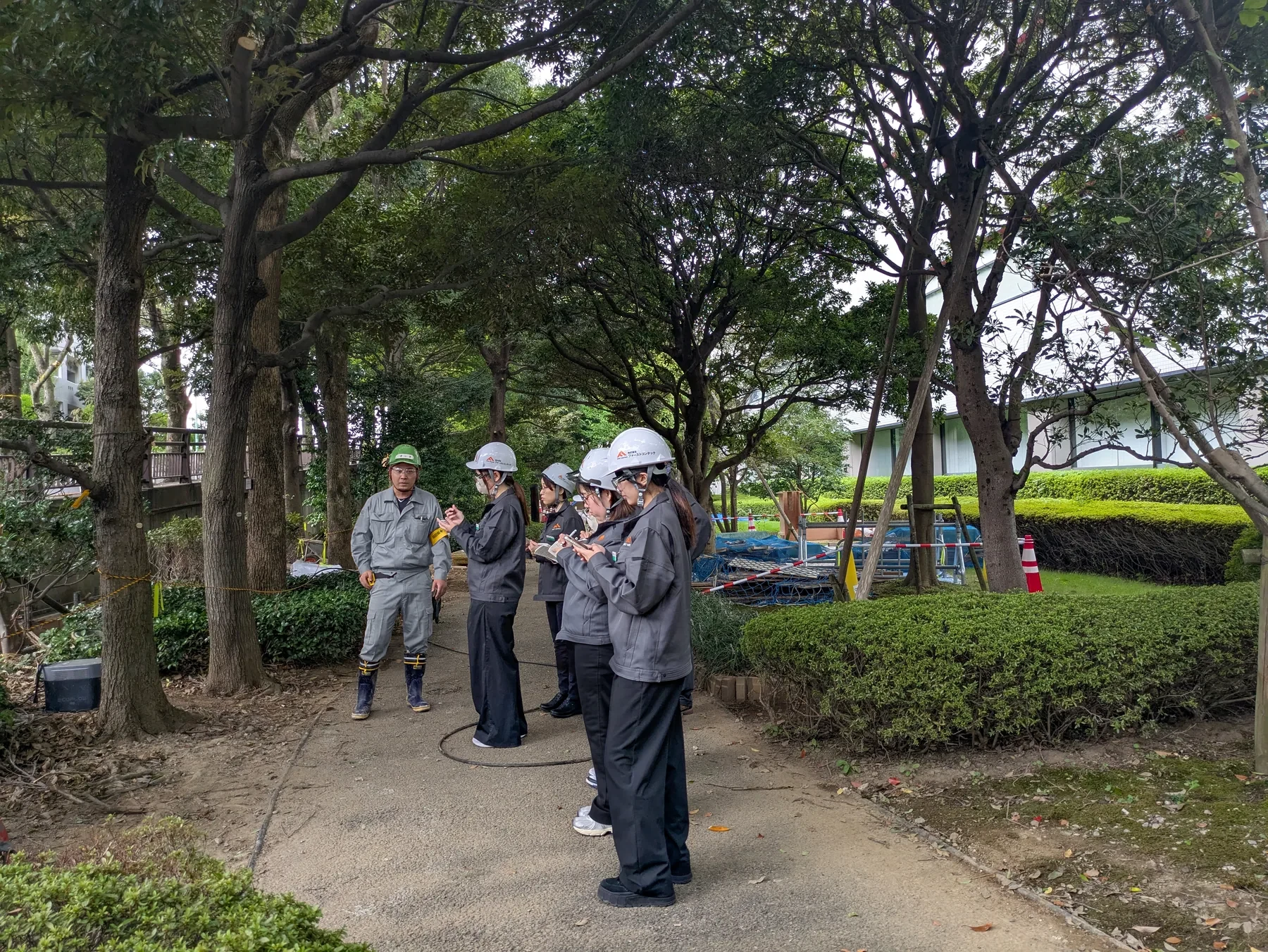 現場を巡回しながら新人に確認ポイントを教える教育担当者