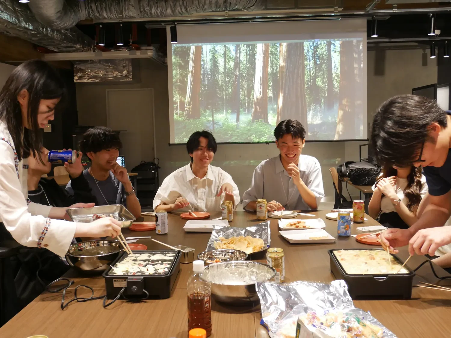 社内交流会で料理を囲む社員