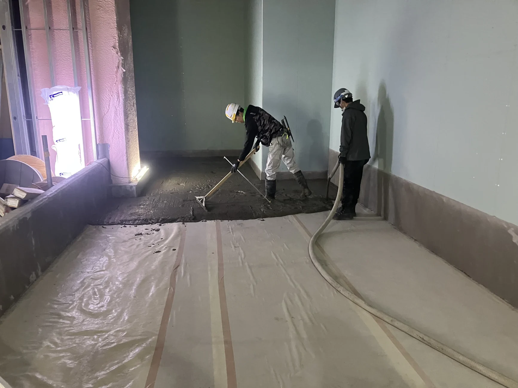 内装改修工事で床面の施工を進める作業員