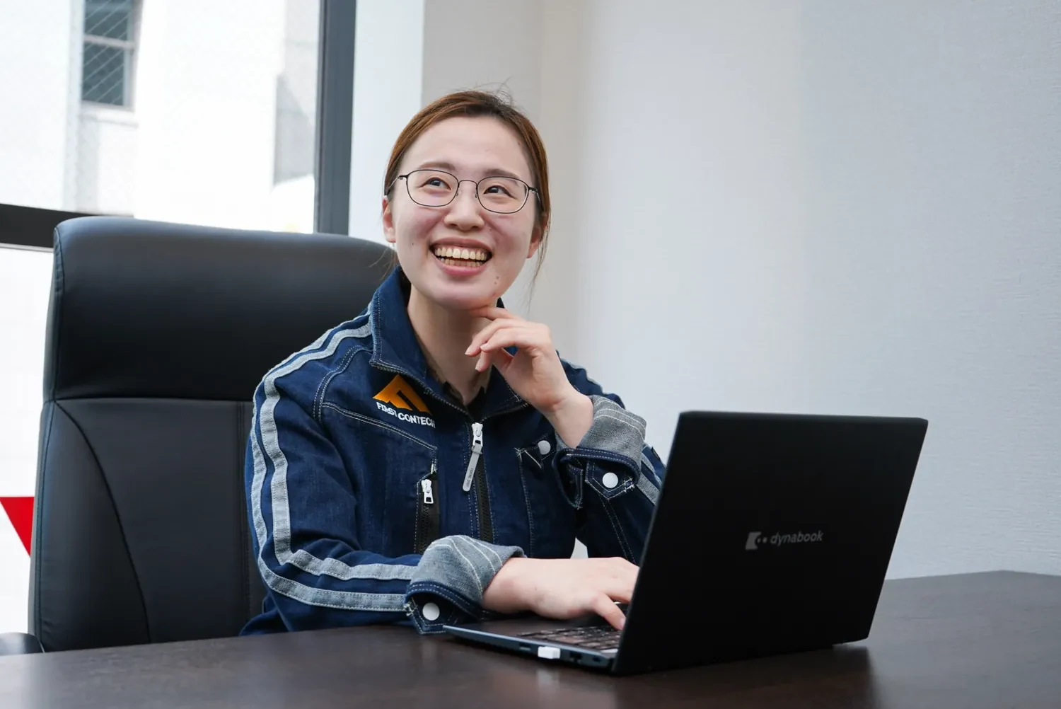 作業着でPCを使い書類や写真管理を行う社員