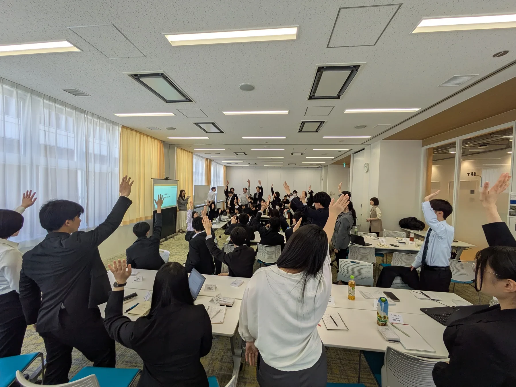 研修で手を挙げる社員たち